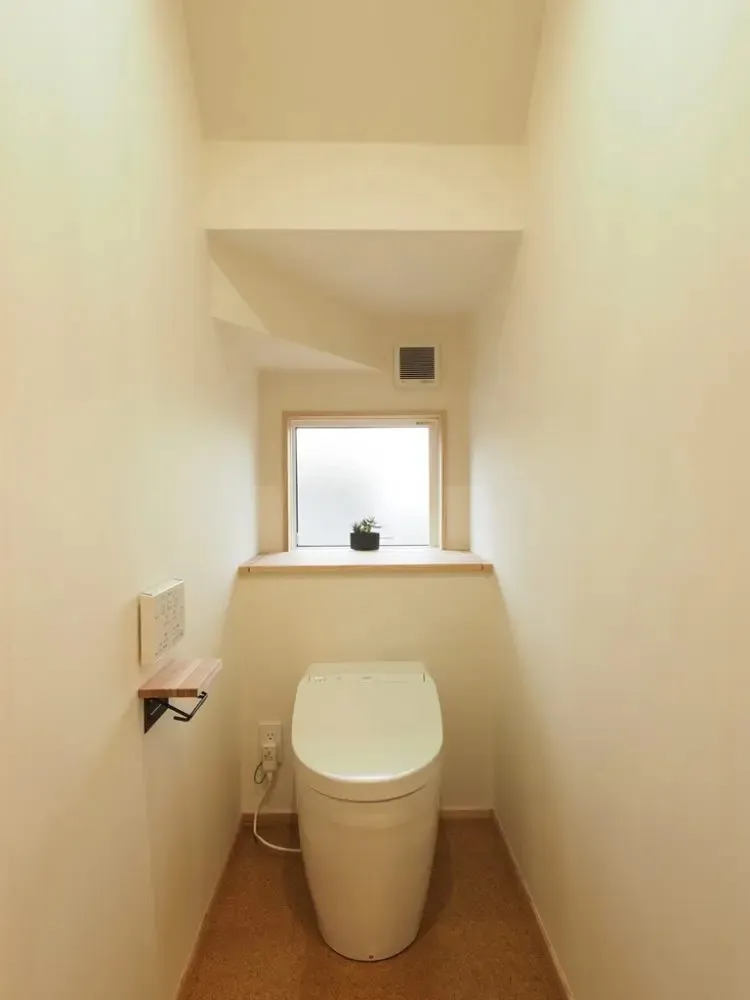 階段下の空間を利用したトイレ。<br>トイレ奥の棚蓋を開けると奥行450深さ400の収納が隠れています。<br>階段下を有効に活用したデザイン。